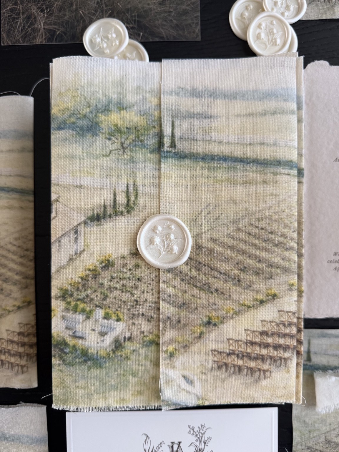 Printed linen invitation wrap with landscape artwork and wax seal